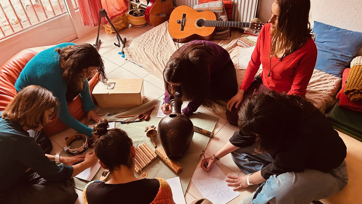 Grupo de familias y niños tumbados en el suelo durante una celebración colectiva con música